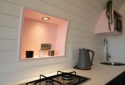 a kitchen with a stove and a mirror on the wall at Celyn in Welshpool