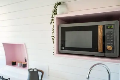 a microwave on a wall above a kitchen counter at Celyn in Welshpool