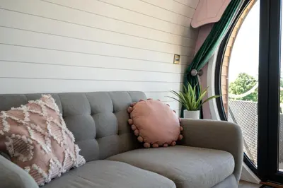a couch with a pillow sitting in front of a window at Celyn in Welshpool