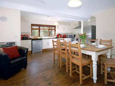 a kitchen and dining room with a table and chairs at Seafield in New Quay