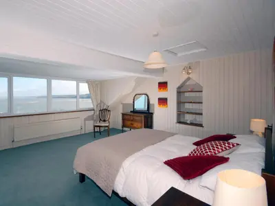 a bedroom with a large bed and a television at Seafield in New Quay