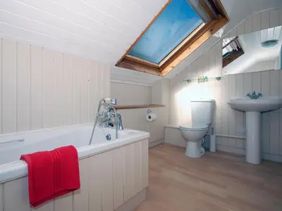 a bathroom with a tub and a sink and a toilet at Seafield in New Quay