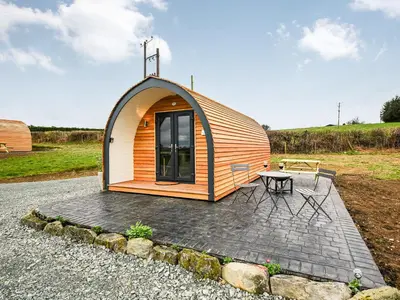 a small cabin with a picnic table in front of it at Cae Bitfel - Cottage in Llanwddyn