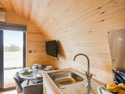 a kitchen with a sink in a tiny house at Cae Bitfel - Cottage in Llanwddyn