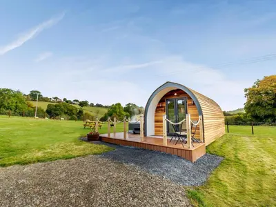 a tiny house in a field with a deck at Chestnut Uk36261 in Llanfair Caereinion