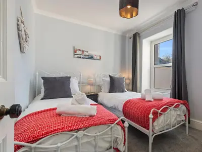a bedroom with two beds and a window at Y Ty Glas - Cottage in New Quay