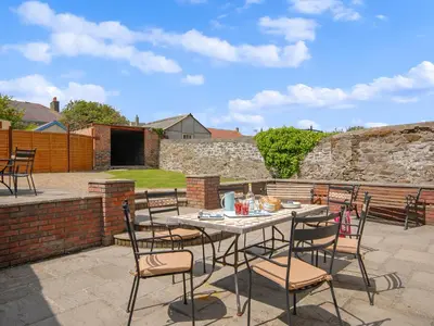 a patio with a table and chairs on a patio at Cerniw - Cottage in Aberaeron