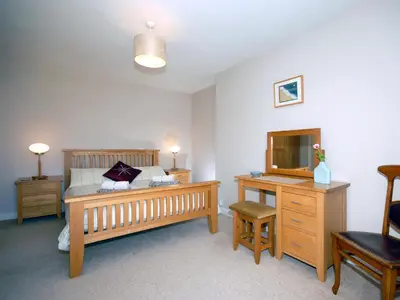 a bedroom with a bed and a desk with a television at Cerniw - Cottage in Aberaeron