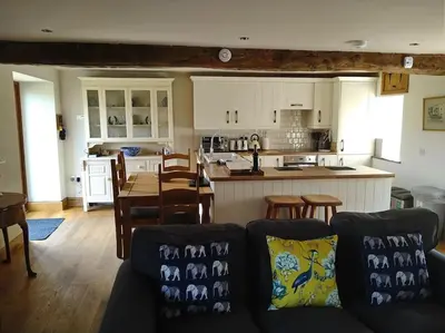 a living room and kitchen with a couch and a table at Wern Ddu, Defynnog - Brecon Beacons in Brecon