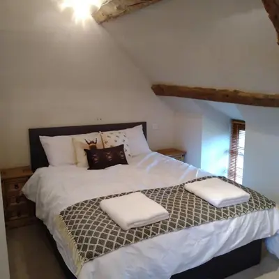 a bedroom with a large bed with white sheets and pillows at Wern Ddu, Defynnog - Brecon Beacons in Brecon
