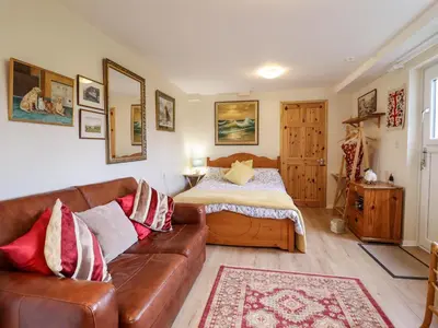 a living room with a couch and a bed at Westoe Hideaway in Llangollen