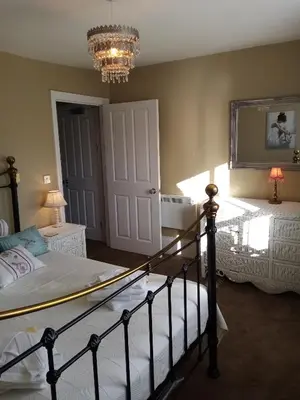 a bedroom with a bed and a chandelier at Pier View Sea View Apartment Aberystwyth Promenade in Aberystwyth