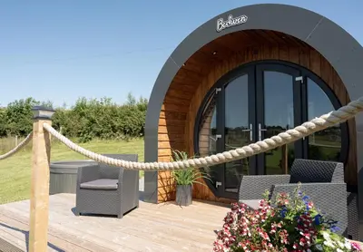 a wooden deck with a rope and chairs and a building at Bedwen in Welshpool