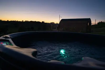 a hot tub with a green light in the water at Bedwen in Welshpool