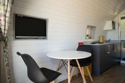 a kitchen with a table and two chairs and a tv at Derwen in Welshpool
