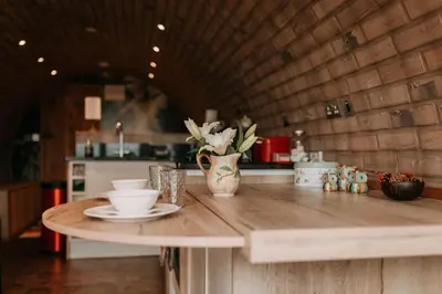 a kitchen counter with a table with a cup and aucer at Owl Hollow in Llansantffraid-ym-Mechain