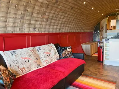 a couch sitting in a room with a kitchen at Owl Hollow in Llansantffraid-ym-Mechain