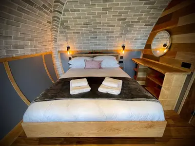 a large bed in a room with a brick wall at Rabbits View in Rhayader