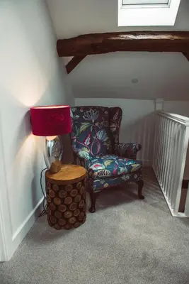 a room with a chair and a lamp and a table at Swallows Rest in Montgomery