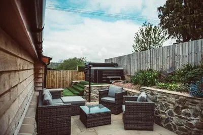 a patio with wicker chairs and a grill in a backyard at Swallows Rest in Montgomery