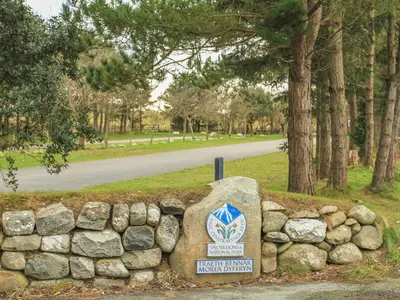 a sign on a stone wall next to a road at Ty'n y Clawdd in Dyffryn