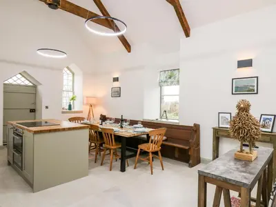 a kitchen and dining room with a table and chairs at Ysgoldy Brynwyre in Llanrhystyd