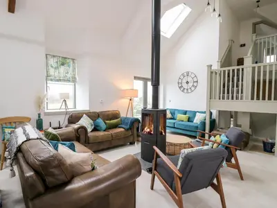 a living room with couches and a wood stove at Ysgoldy Brynwyre in Llanrhystyd