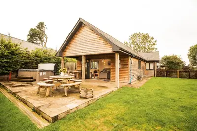 a backyard patio with a picnic table and a grill at Caban Nant Ddu in Nantmel