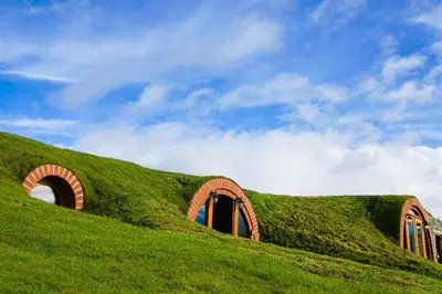 a grassy hill with a building with arched windows at Foxes View in Rhayader