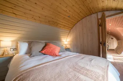 a bed in a room with a wooden ceiling at Foxes View in Rhayader