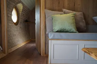 a bed with a green pillow on it in a room at Hare's View in Rhayader