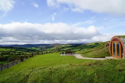 a building on a grassy hill with a pathway at Hare's View in Rhayader