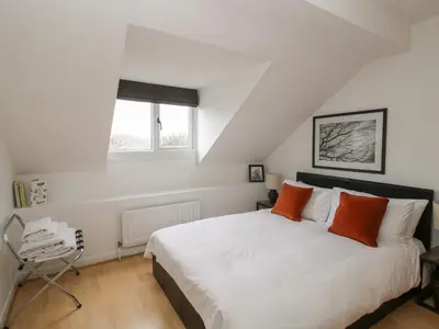 a bedroom with a large white bed with orange pillows at Laurgeths House in Bishops Castle
