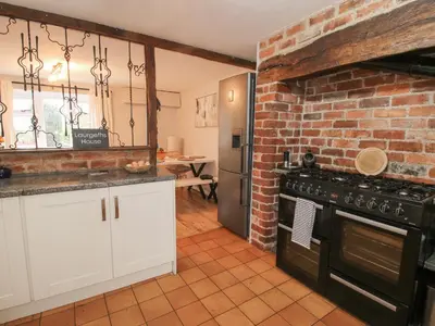 a kitchen with a brick wall and an oven at Laurgeths House in Bishops Castle