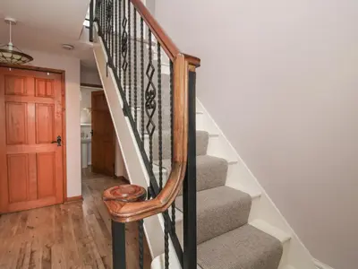 a staircase with a wooden rail and a wooden door at Laurgeths House in Bishops Castle