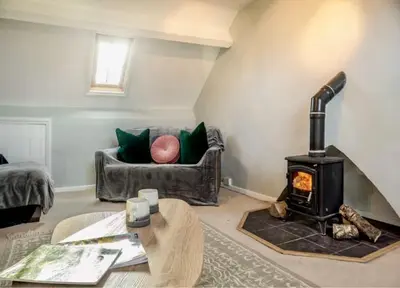 a living room with a couch and a wood stove at Jack's House in Tywyn
