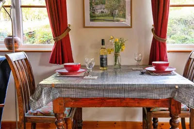 a dining room table with a bottle of wine and glasses at Finest Retreats - Great Cantal Granary in Llandrindod Wells