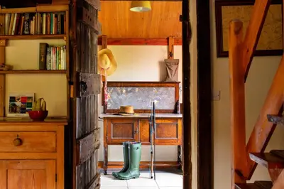 a room with a table and a pair of boots at Finest Retreats - Great Cantal Granary in Llandrindod Wells