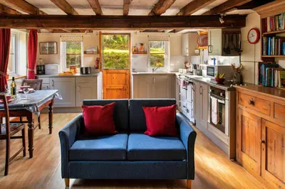 a living room with a blue couch in a kitchen at Finest Retreats - Great Cantal Granary in Llandrindod Wells