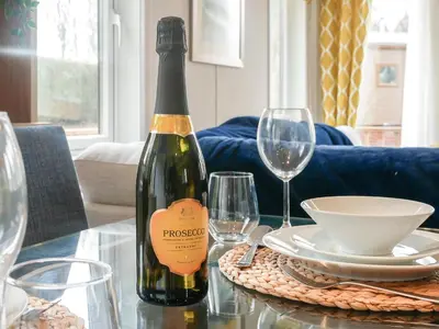 a bottle of wine sitting on a table with glasses at Marlow Lodge in Hyssington