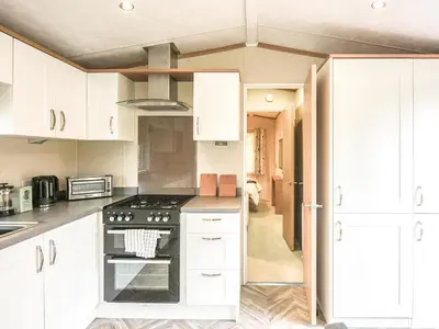 a kitchen with white cabinets and a stove top oven at Marlow Lodge in Hyssington