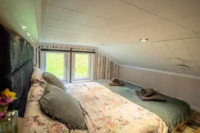 a bedroom with a large bed with two stuffed animals on it at Hillside Lodge in Nantmel