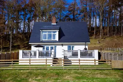 a white house with a fence in front of it at Lower Pentre in Llanddewi Ystradenny
