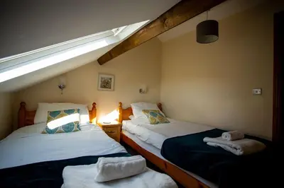 two twin beds in a room with a slanted ceiling at Pentre Fach in Llanddewi Ystradenny