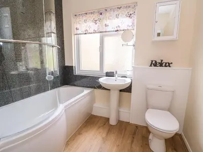 a bathroom with a sink and a toilet and a bath tub at Tegfan Bungalow in Pant-y-dwr