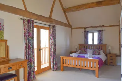 a bedroom with a bed and two windows at The Hayloft in Knighton