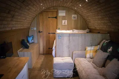 a living room with a couch and a room with an arch at The Prancing Pony in Llanrhaeadr-ym-Mochnant