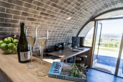 a bottle of wine and two glasses on a counter at Valley View in Llanfair Caereinion