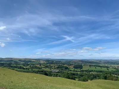 a view of a green field with a blue sky at Valley View in Llanfair Caereinion