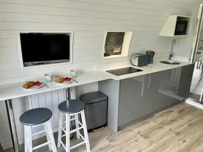 a kitchen with a counter with two stools and a sink at Y Dderwen in Oswestry